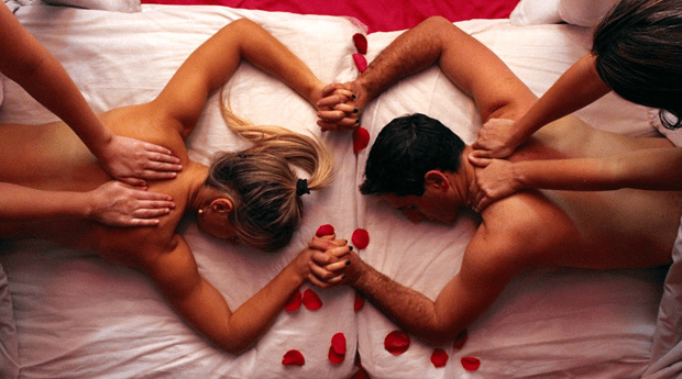Homem e mulher de mãos dadas recebendo massagem.