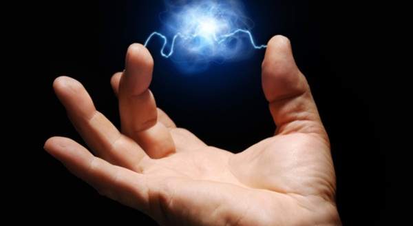 Foto de dois dedos segurando uma bola de energia.